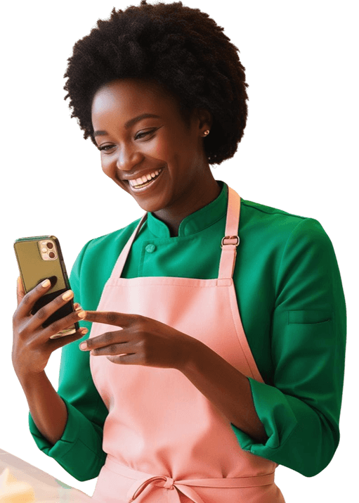 Confeiteira utilizando o App Confeitaria Agenda que simplifica a gestão de confeitarias Confeiteira profissional sorrindo enquanto usa o aplicativo Confeitaria Agenda em seu celular, na cozinha da confeitaria